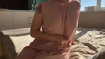 A Woman In A Gentle Pink Dress Indulges In Self-Pleasure